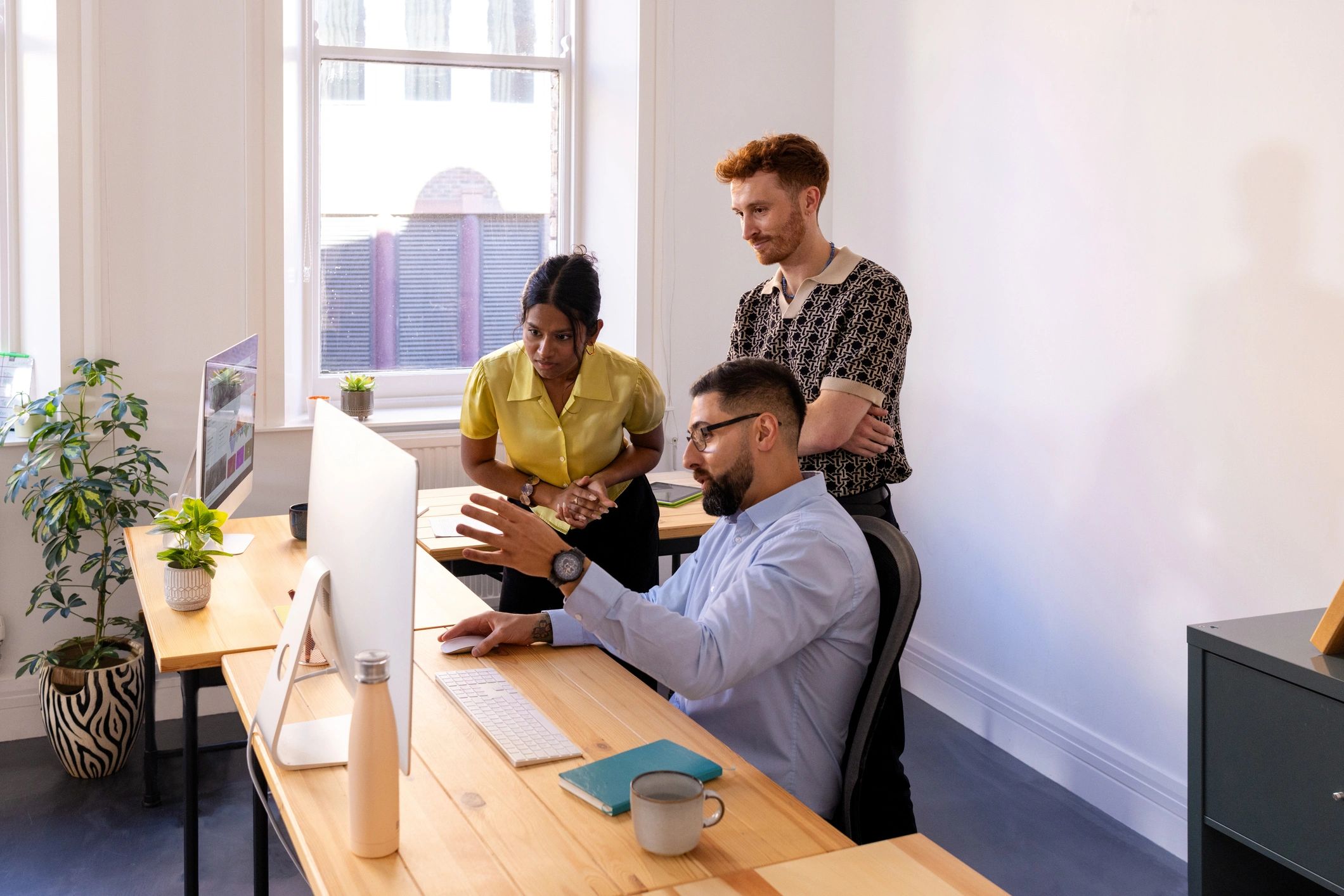 Team collaborating around a computer to improve guided workflows